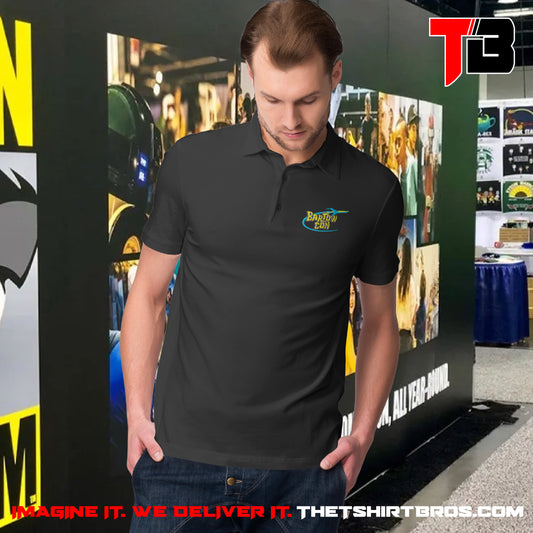 Man wearing a black polo shirt with a logo in front of a promotional backdrop for The T-Shirt Bros.