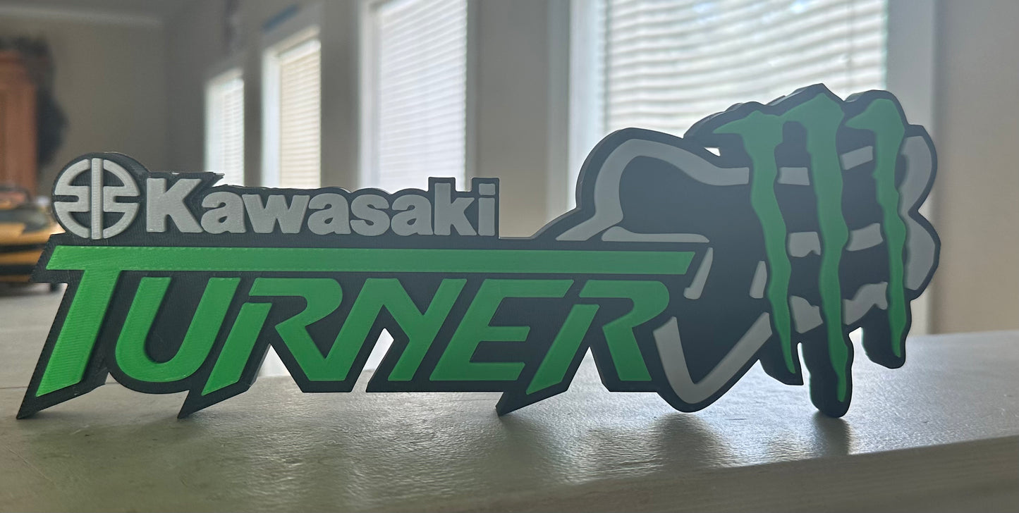 Kawasaki Turner logo with a motorcycle graphic on a surface