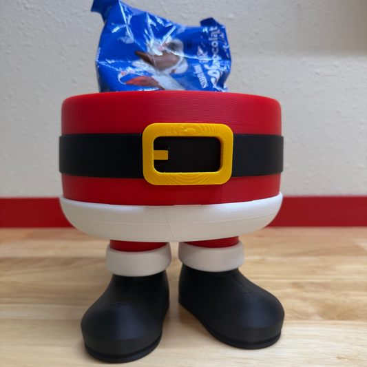 Santa Claus-themed container with a yellow buckle on a wooden surface.