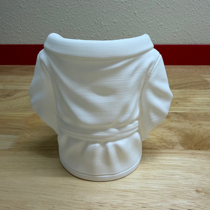 White ceramic vase on a wooden surface with a plain wall background