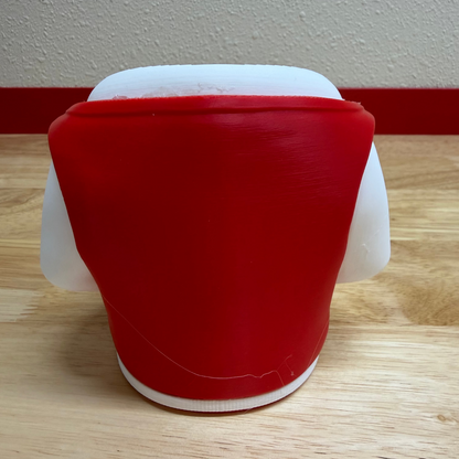 Red and white container on a wooden floor with a white wall background