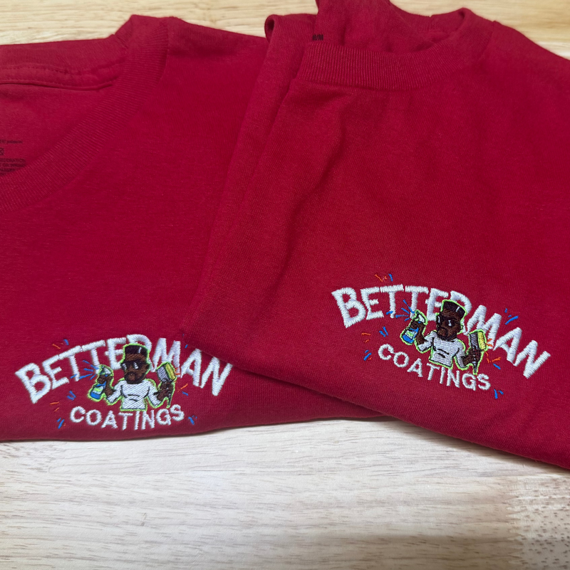 Folded red shorts with 'BETTERMEN' branding on a wooden surface