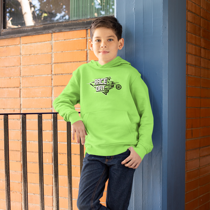 Child wearing a bright green hoodie with text and graphics, standing against a blue wall.