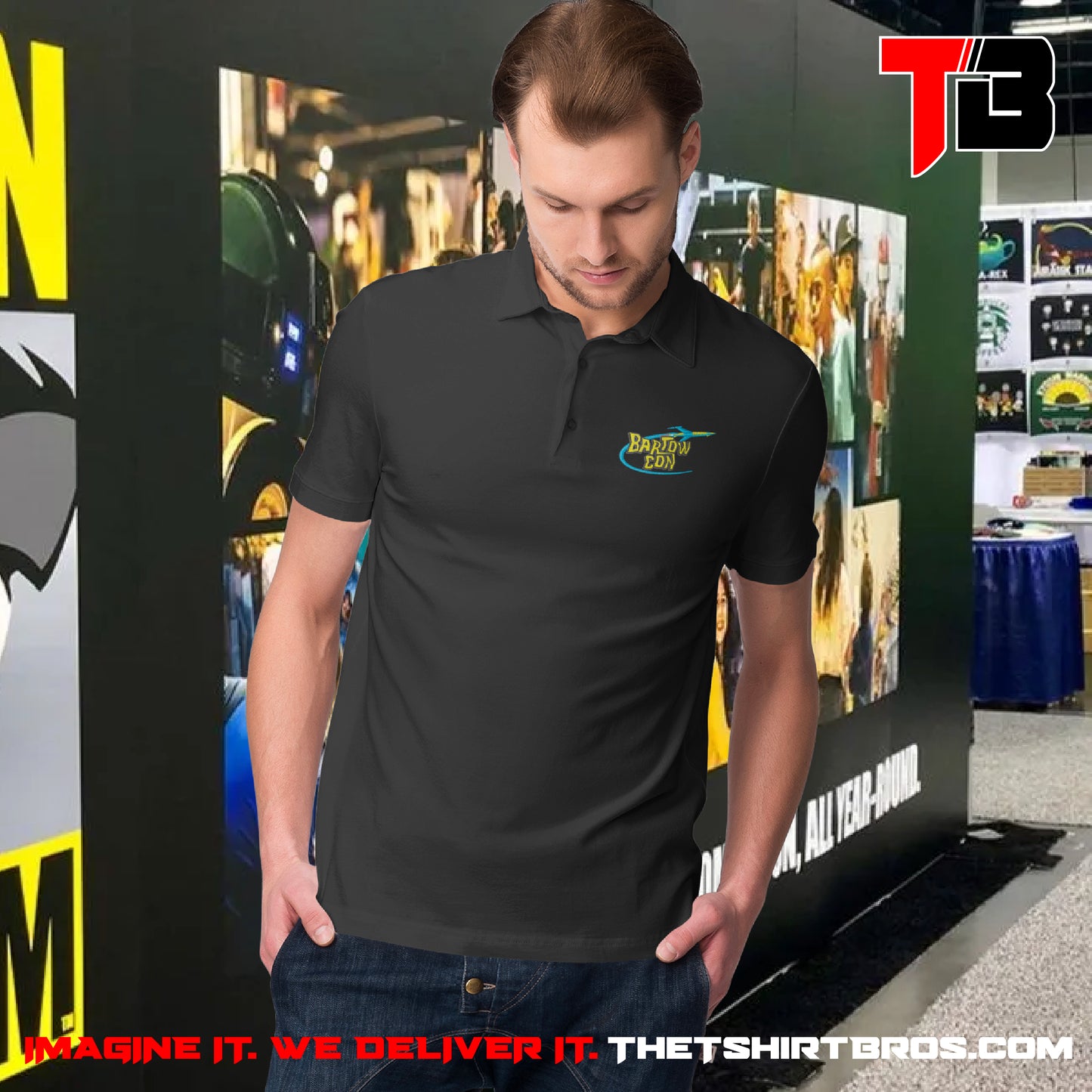 Man wearing a black polo shirt with a logo in front of a promotional backdrop for The T-Shirt Bros.