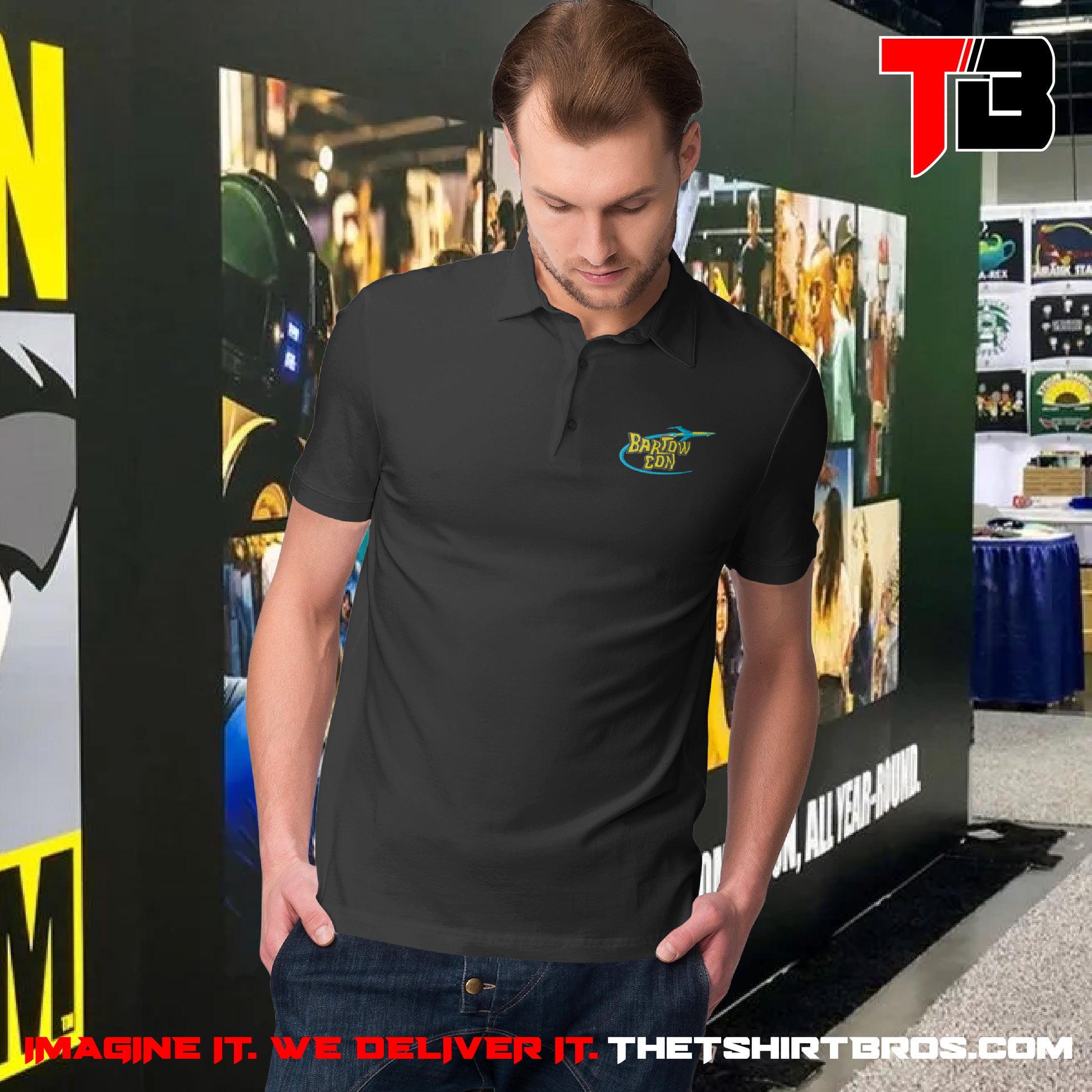 Man wearing a black polo shirt with a logo in front of a promotional backdrop for The T-Shirt Bros.