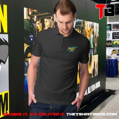 Man wearing a black polo shirt with a logo in front of a promotional backdrop for The T-Shirt Bros.