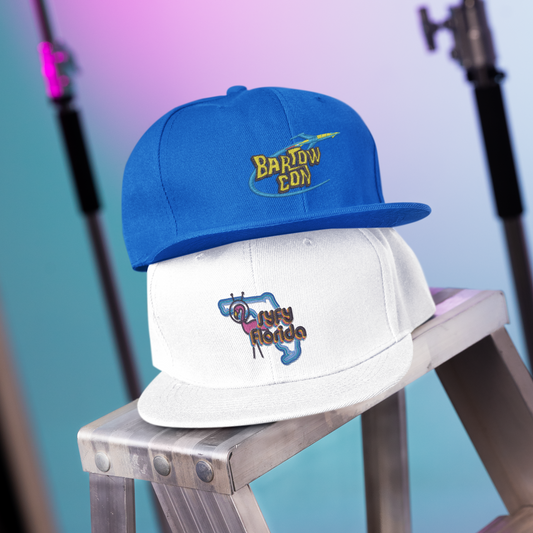 Two hats, one blue and one white with logos, on a metal stool against a blurred background.
