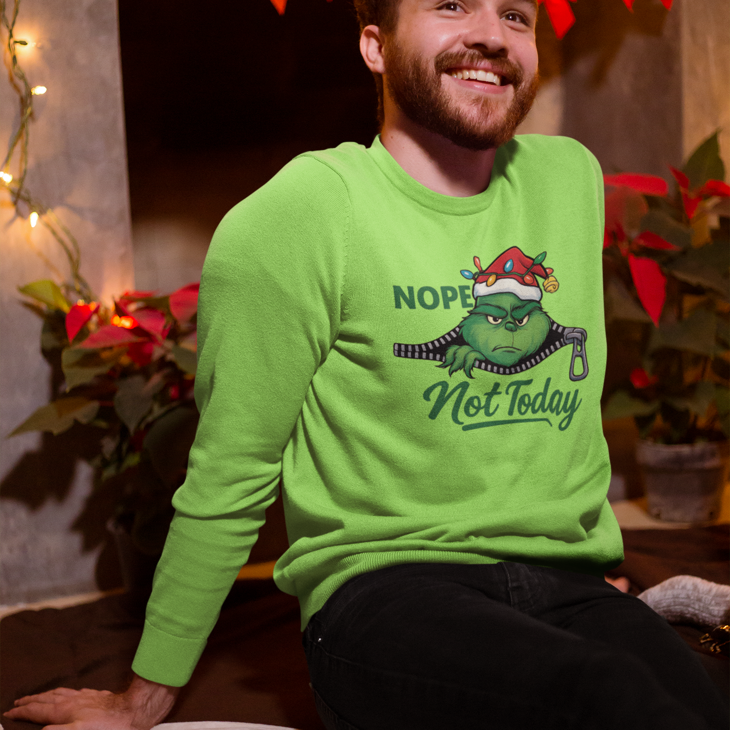 Man wearing a green sweatshirt with a graphic design sitting in a decorated room.